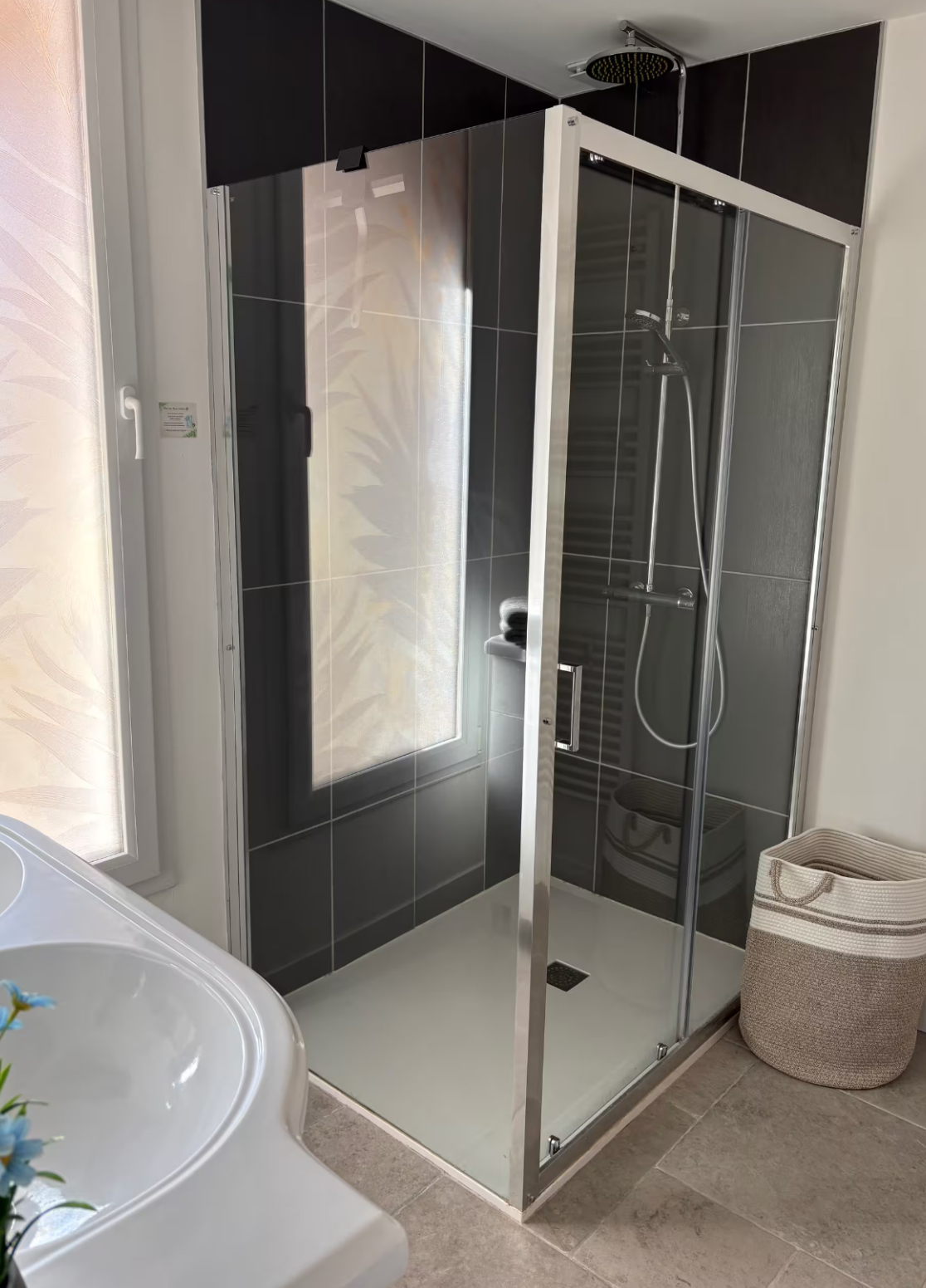 Salle de bain avec cabine de douche en verre et carrelage noir